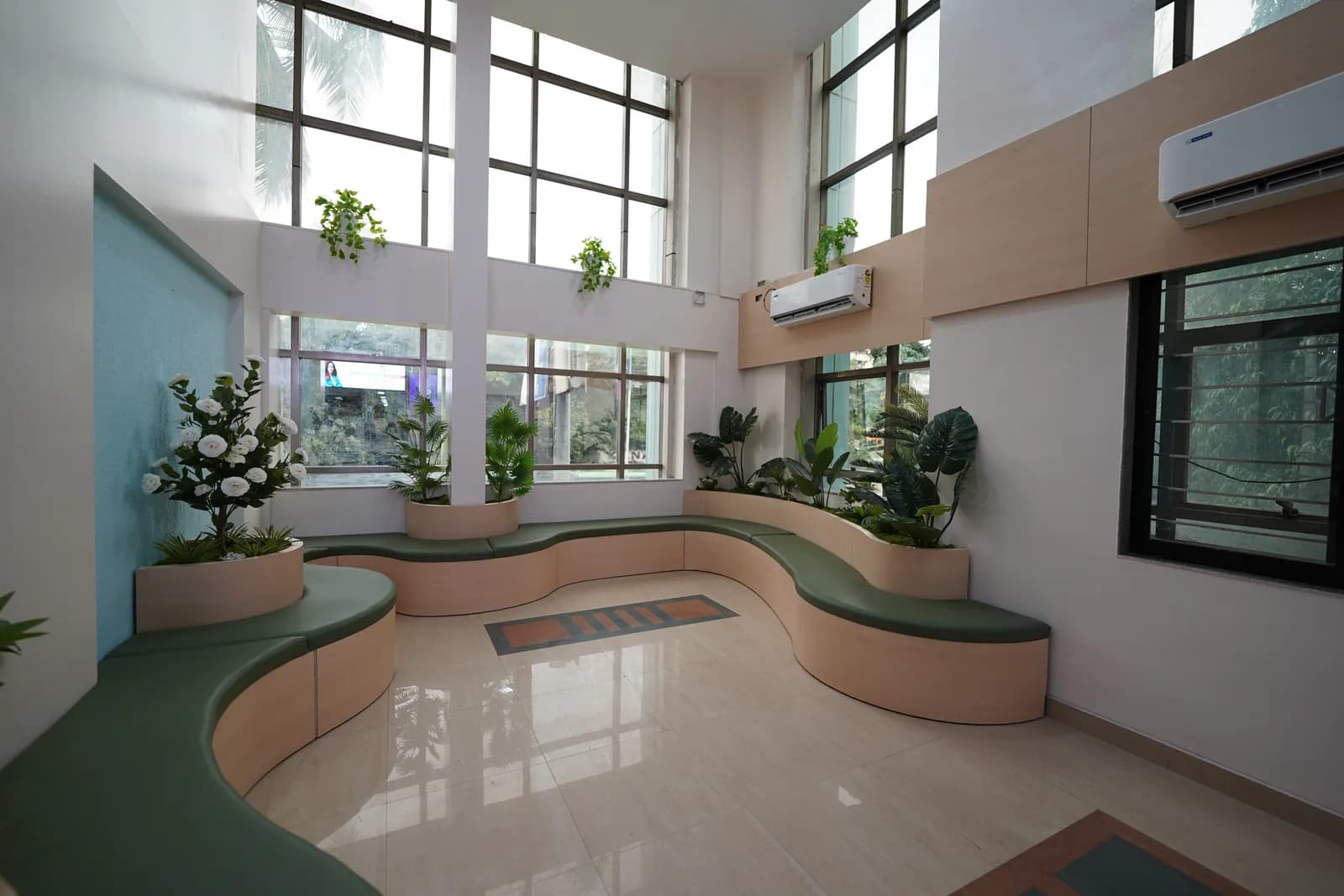 Daylit waiting area with curved benches and plants